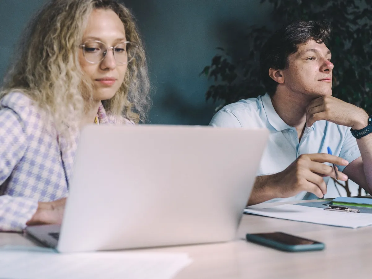 Two colleagues working together at a laptop.