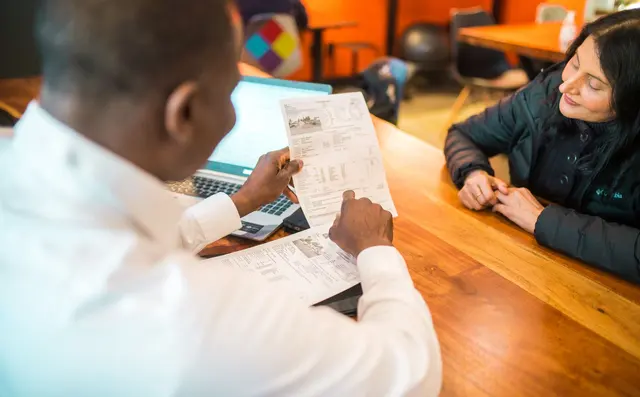 An AI consultant walking a client through findings at a laptop