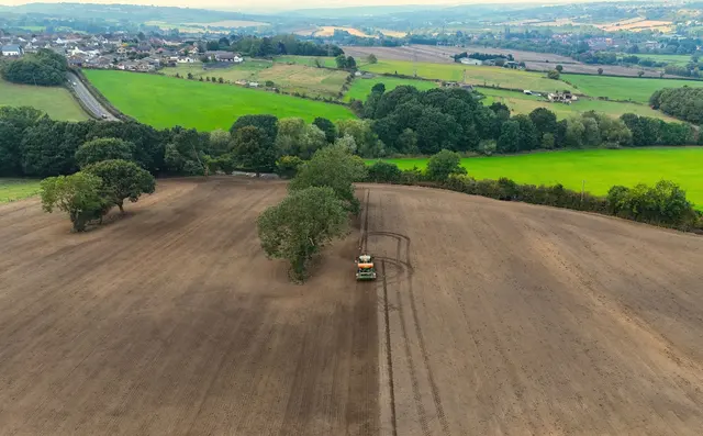 Tractor working a field with GPS-guided precision equipment