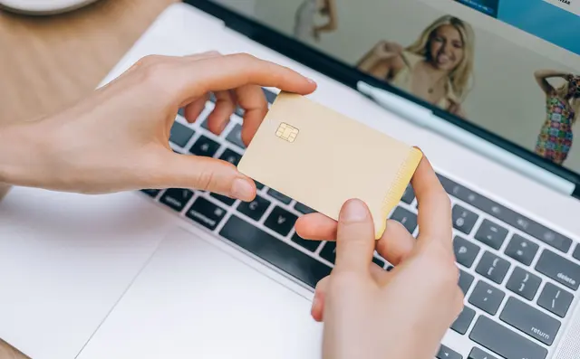 Person shopping online with a laptop and card
