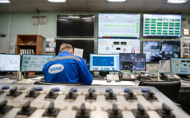 Operator monitoring screens in a control room