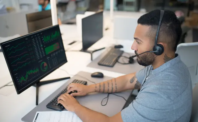 Analyst monitoring screens in a security operations room