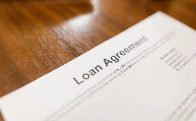 Loan documents being signed at a bank desk