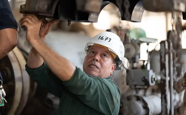 Engineer servicing a machine on a factory floor