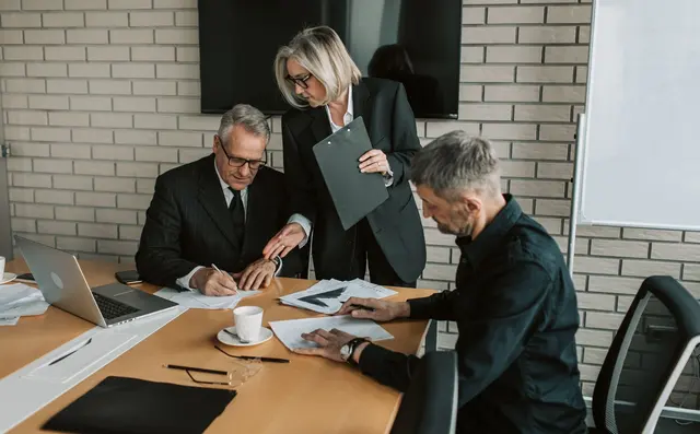 Professionals reviewing documents in a boardroom