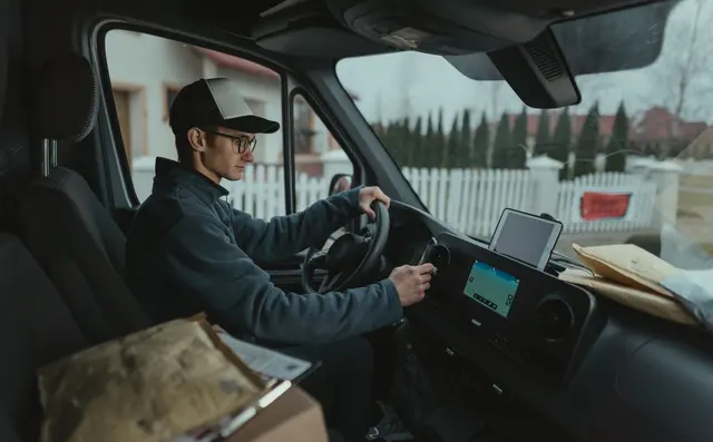 Delivery driver planning a route at a van