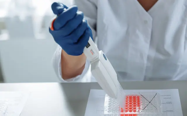 Researcher using a pipette at a laboratory bench
