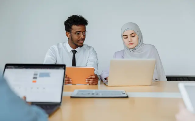 Colleague showing work on a laptop to a coworker