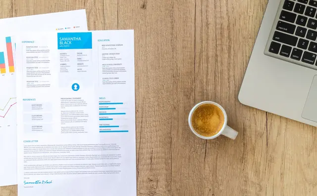A stack of printed CVs on a desk