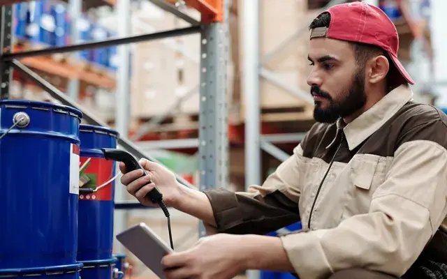 A warehouse worker scanning stock with a handheld device and tablet