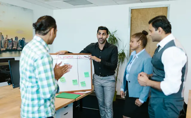A team conferring while standing in an office