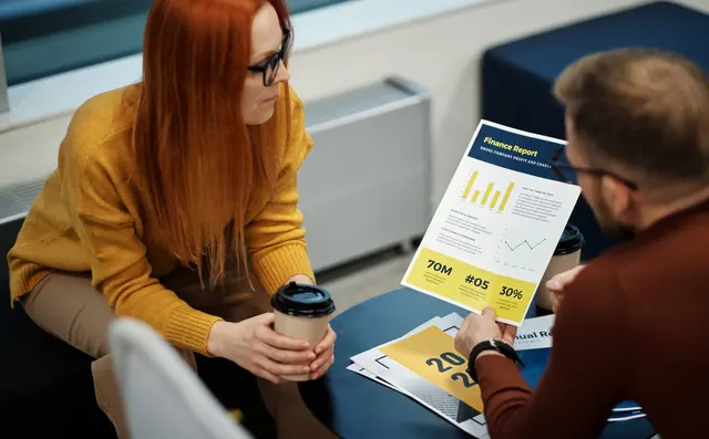 A consultant reviewing a printed report with a client
