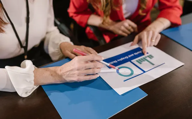 A team reviewing printed charts together around a table