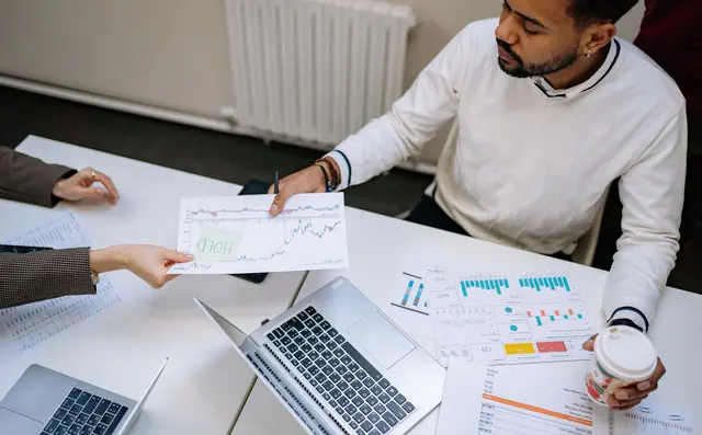 Two colleagues analysing charts across a desk