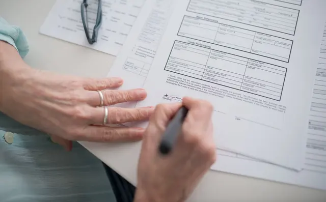 Hands filling in an official form