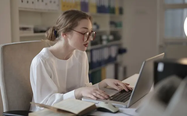 Een medewerker werkt geconcentreerd aan een laptop