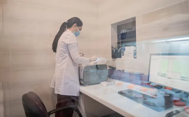 A laboratory technician examining a sample on screen