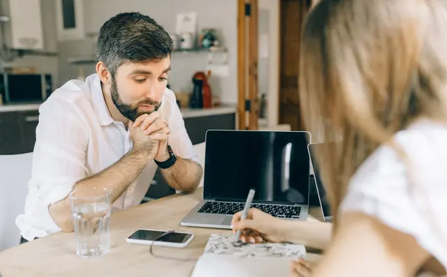 Someone thinking through an idea at a laptop