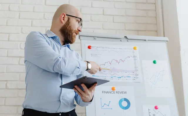 An analyst presenting charts at a whiteboard