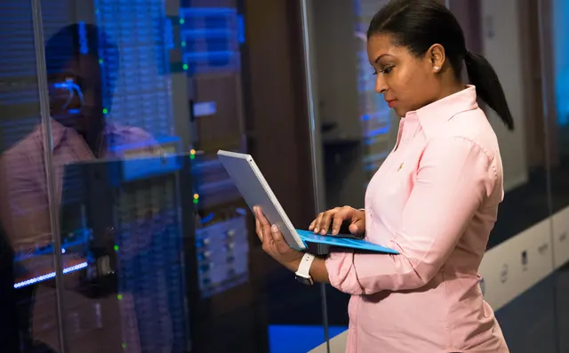 An engineer with a tablet in a server room