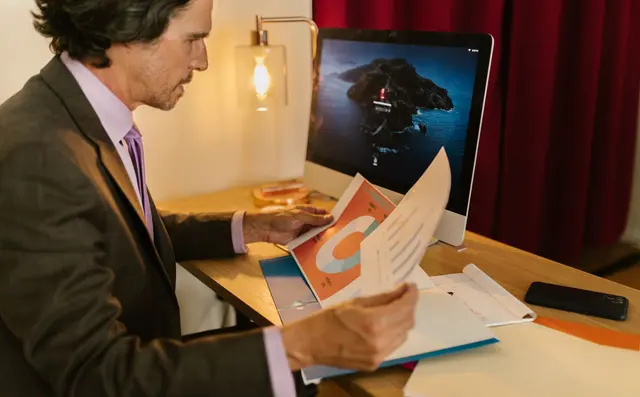 An analyst comparing a report on screen with the printed source
