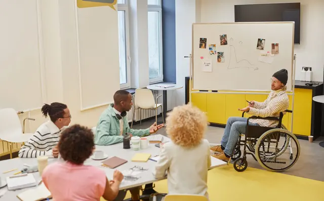 Een team bespreekt vragen bij een whiteboard