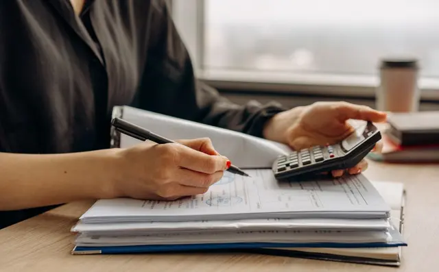 Een jaarbudget wordt doorgerekend met een rekenmachine