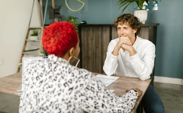 Twee mensen in gesprek aan een tafel