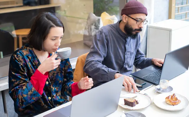 Twee zelfstandigen werken samen aan laptops