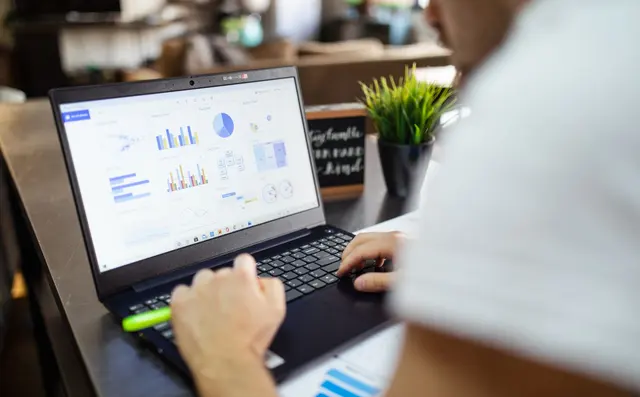 Someone working on a stock overview on a laptop