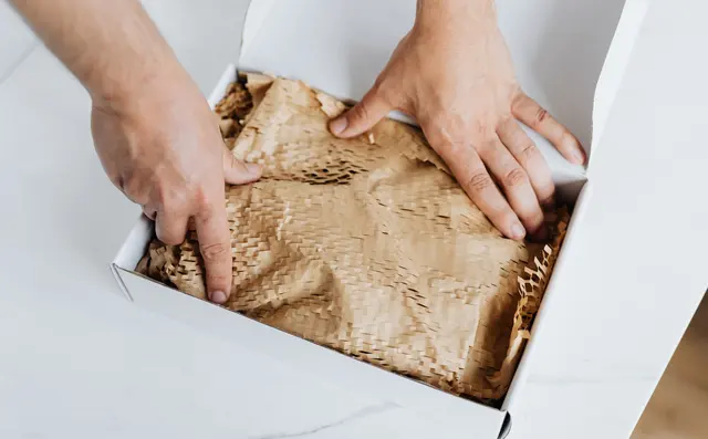 Hands packing an order into a box