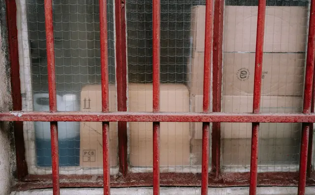 A secured storage area with stock behind a barrier