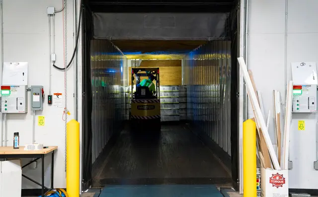 A forklift entering a trailer at the loading dock