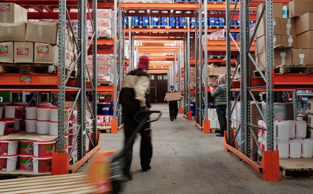 A worker walking an aisle of pallet racking